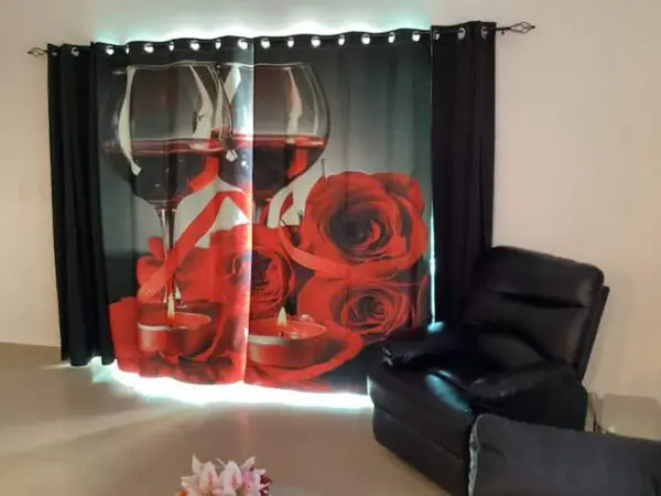 Ocean Front Lavish *Jr Penthouse* Exquisite Views with a printed design of red roses and wine glasses, illuminated by LED lights, beside a black leather sofa in a room.