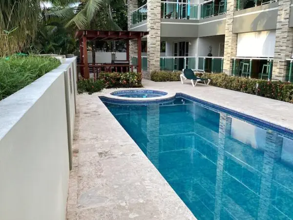 Outdoor swimming pool with a jacuzzi near Ocean Front Lavish *Jr Penthouse* Exquisite Views, surrounded by a patio and garden plants.