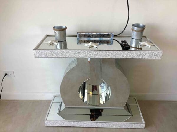 A mirror table with two speakers on top of it.