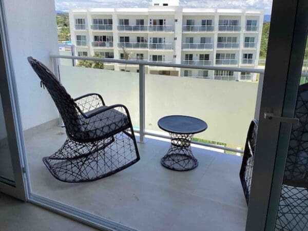 A balcony with two chairs and a table