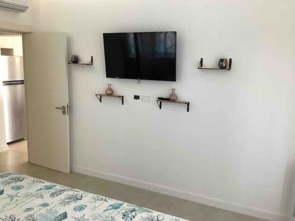 A bedroom with a bed and tv mounted on the wall