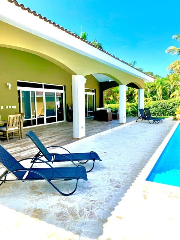 A pool with two lounge chairs and a swimming pool.