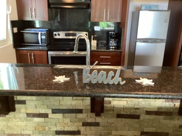 A kitchen interior featuring modern appliances with a "beach" themed decoration on the counter, including starfish models of Ocean Front Lavish *Jr Penthouse* Exquisite Views.