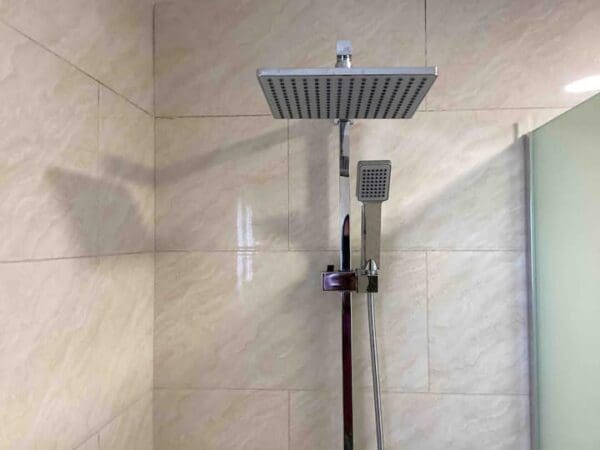 A shower head with a hand held shower attachment.