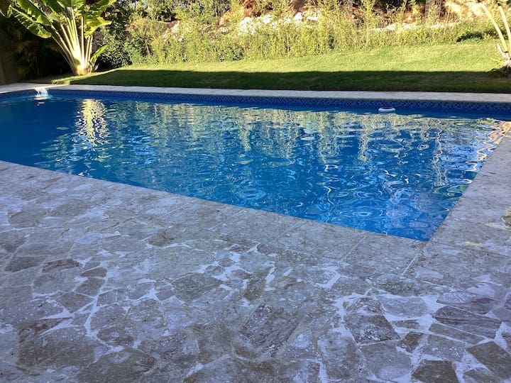 A pool with water in it and grass behind it.