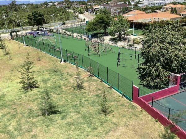 A tennis court with trees and bushes in the background.