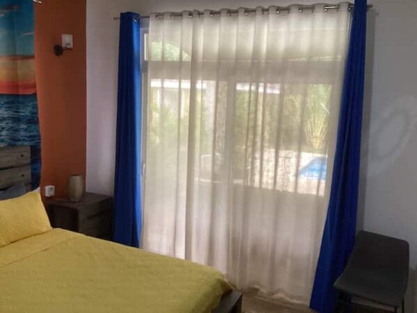 A bedroom with a bed and blue curtains