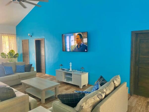 A living room with blue walls and white furniture.