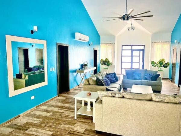 A living room with blue walls and white furniture.