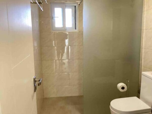 A bathroom with a toilet and shower stall.