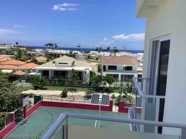 A balcony view of the ocean and houses.