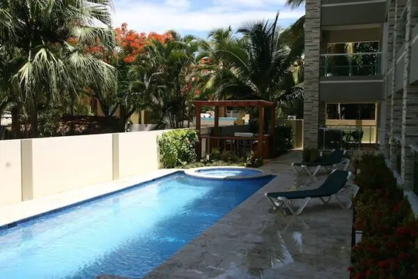 Ocean Front Lavish Jr Penthouse with Exquisite Views on the patio of a modern building, surrounded by tropical plants.