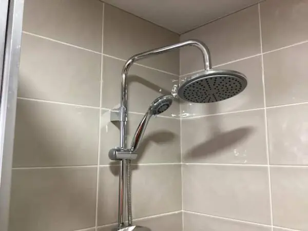 A modern Ocean Front Lavish *Jr Penthouse* Exquisite Views fixture featuring a large overhead showerhead and an adjustable handheld nozzle mounted on tiled walls.