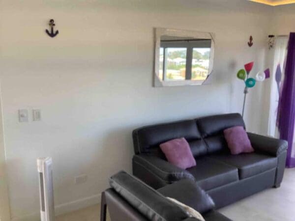 A living room with leather furniture and a window.