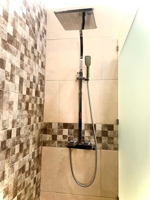 A shower with tile walls and tiled floors