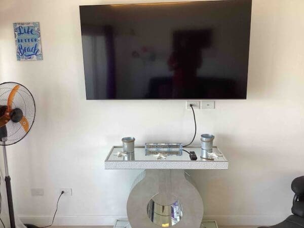 A television mounted on the wall above a table.